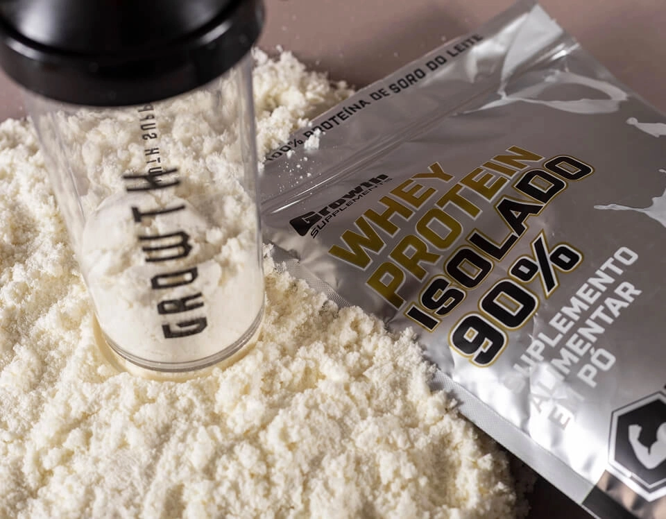 IMAGEM ILUSTRATIVA - WHEY PROTEIN ISOLADO AO LADO E UMA COQUETELEIRA GROWTH SUPPLEMENTS